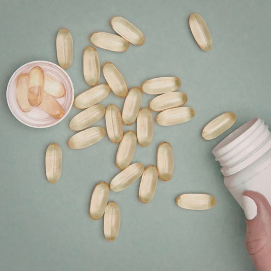 “Hair supplement capsules and vitamins alongside a topical hair serum, illustrating the difference between internal and external approaches to hair health after 40.